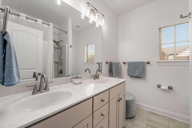 bathroom with tile patterned flooring, vanity, and walk in shower