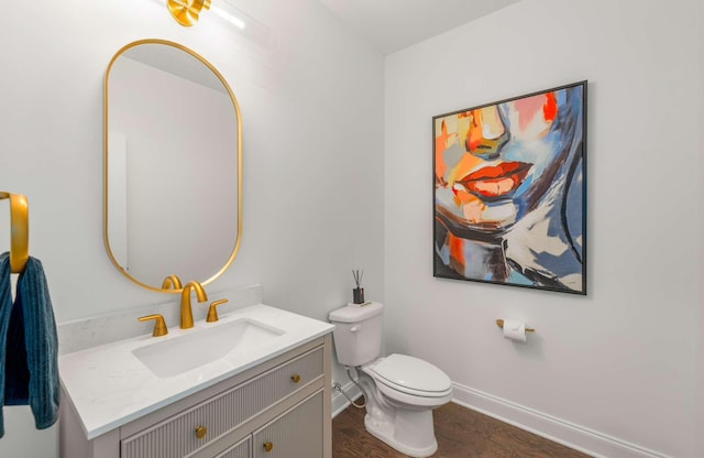 bathroom with hardwood / wood-style floors, vanity, and toilet