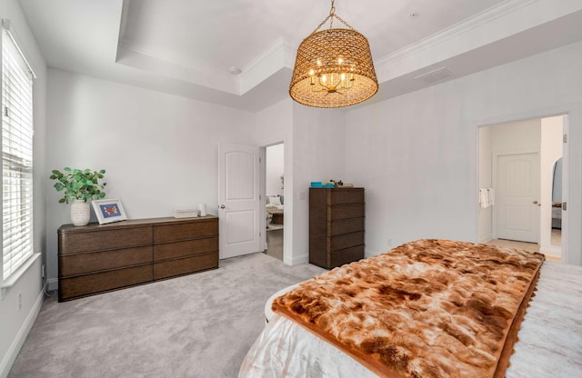 bedroom with a chandelier, ornamental molding, a tray ceiling, and light colored carpet