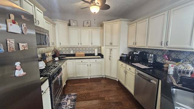 kitchen with dark hardwood / wood-style floors, tasteful backsplash, appliances with stainless steel finishes, and cream cabinets