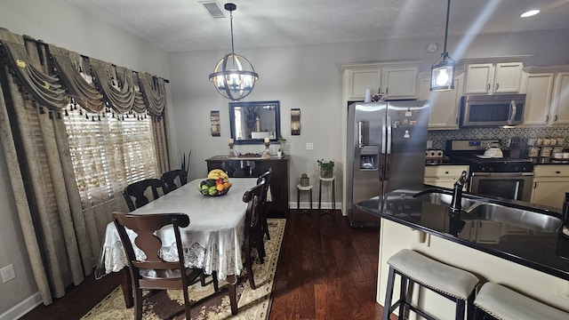 dining room featuring an inviting chandelier, dark wood-type flooring, and sink