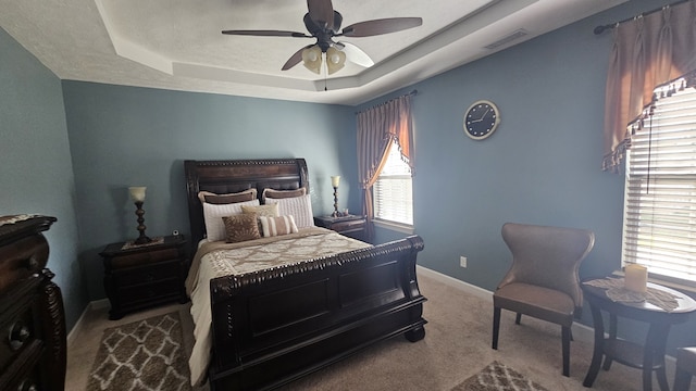 bedroom featuring carpet flooring, ceiling fan, and a tray ceiling