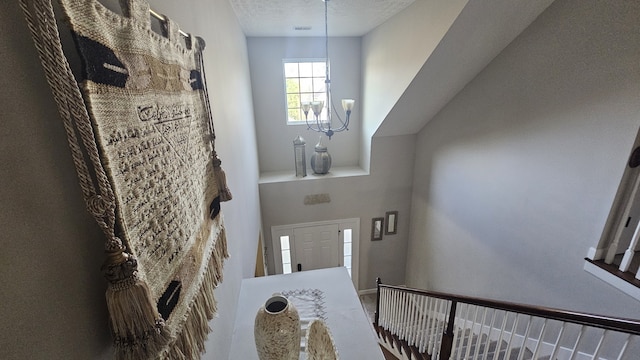 foyer featuring a chandelier and a textured ceiling