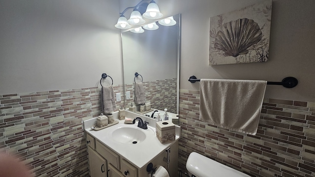 bathroom featuring vanity, tile walls, and toilet