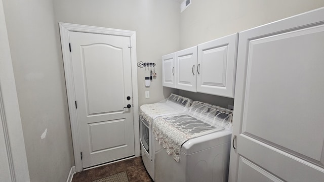 clothes washing area with cabinets and separate washer and dryer