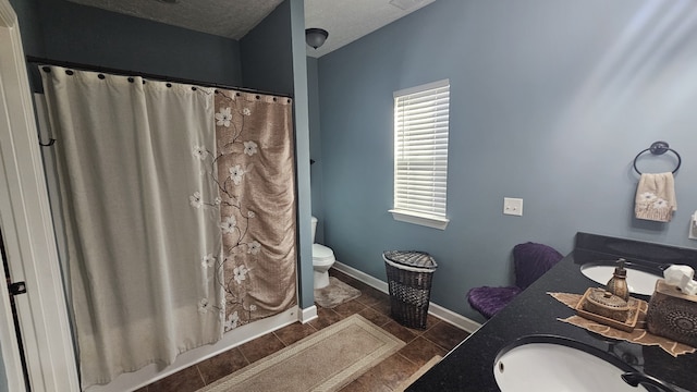 bathroom featuring vanity, tile patterned flooring, toilet, a textured ceiling, and walk in shower