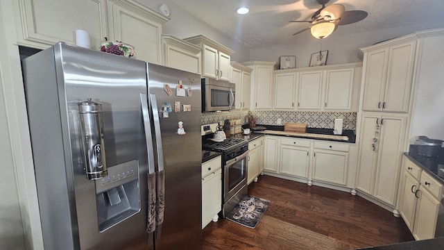 kitchen featuring decorative backsplash, appliances with stainless steel finishes, ceiling fan, cream cabinets, and dark hardwood / wood-style floors