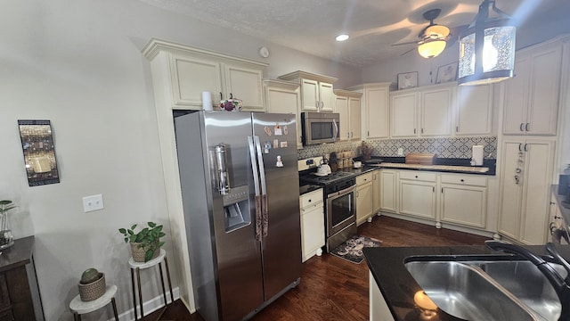 kitchen featuring sink, stainless steel appliances, tasteful backsplash, dark hardwood / wood-style flooring, and cream cabinetry