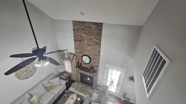 living room featuring hardwood / wood-style floors, ceiling fan, a fireplace, and high vaulted ceiling