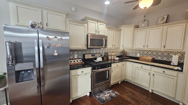 kitchen with backsplash, stainless steel appliances, dark hardwood / wood-style floors, and cream cabinetry