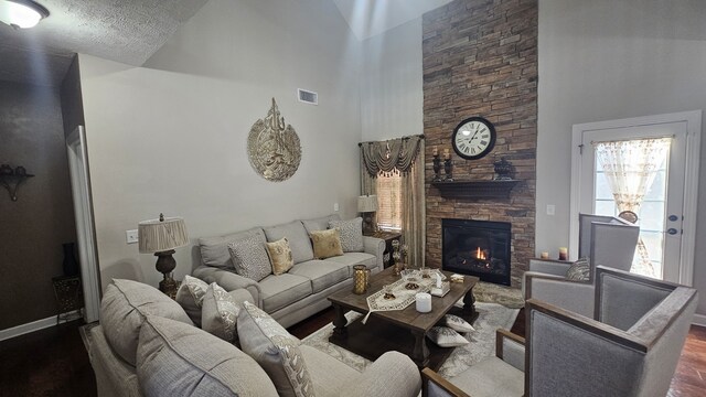 living room featuring a fireplace, high vaulted ceiling, and hardwood / wood-style flooring