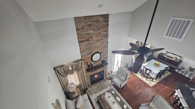 unfurnished living room with a stone fireplace, high vaulted ceiling, and hardwood / wood-style flooring