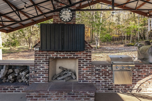 view of patio / terrace with a gazebo, area for grilling, an outdoor brick fireplace, and exterior kitchen