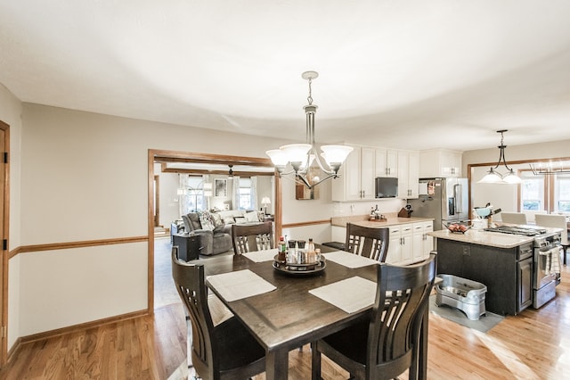 dining area featuring light wood-type flooring and an inviting chandelier