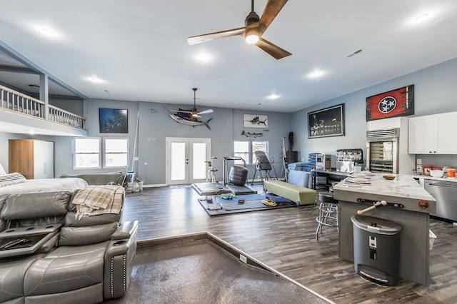 living room with ceiling fan, dark hardwood / wood-style flooring, a high ceiling, and french doors