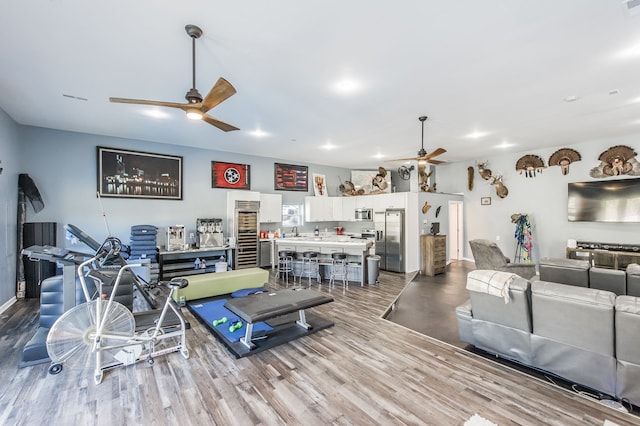 living room with ceiling fan, light hardwood / wood-style flooring, and sink