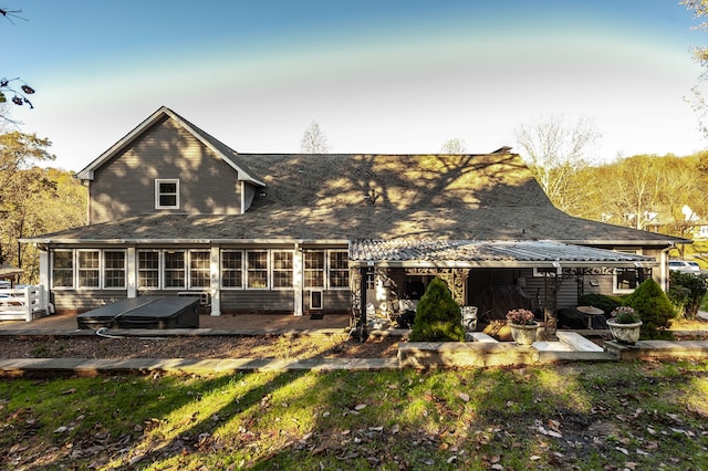 rear view of property with a sunroom and a patio