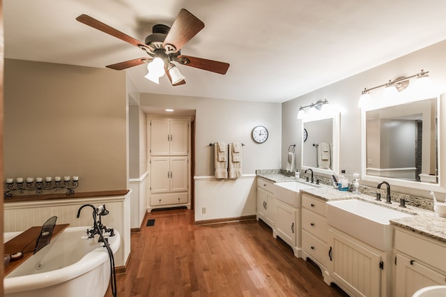 bathroom featuring a bathing tub, vanity, ceiling fan, and wood-type flooring