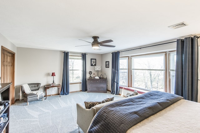 bedroom featuring multiple windows, ceiling fan, and light carpet