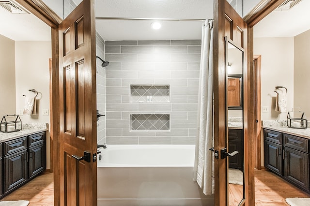 bathroom with wood-type flooring, vanity, and shower / tub combo with curtain