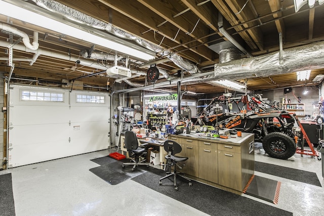 garage with a workshop area and a garage door opener