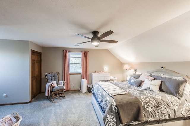 bedroom with carpet, vaulted ceiling, ceiling fan, a textured ceiling, and a closet