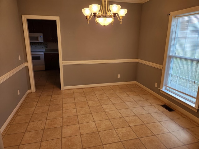 unfurnished room featuring light tile patterned floors, crown molding, and a chandelier