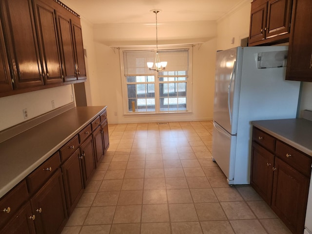 kitchen with white fridge, hanging light fixtures, and an inviting chandelier