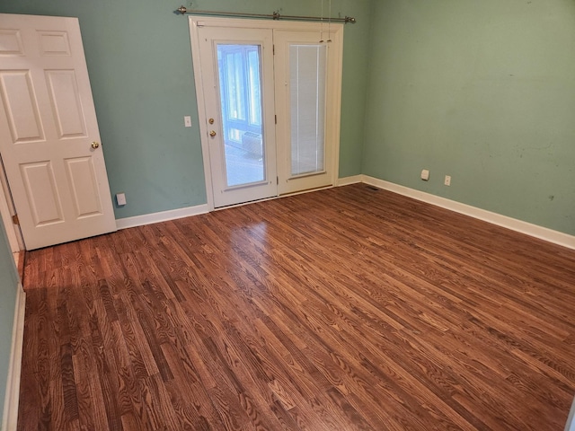 spare room featuring dark wood-type flooring