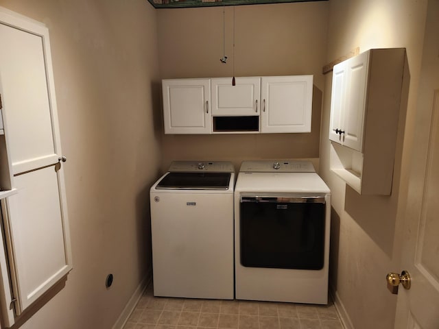 washroom featuring cabinets, light tile patterned floors, and washer and dryer