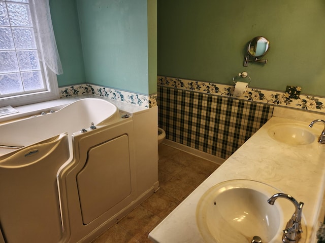 bathroom with tile patterned flooring, vanity, toilet, and a washtub