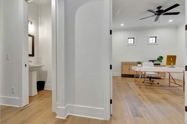 office area with light wood-type flooring, ceiling fan, crown molding, and sink