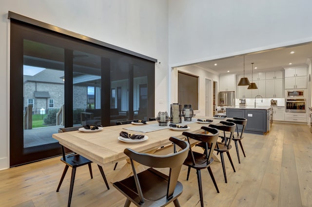 dining space with sink and light hardwood / wood-style flooring