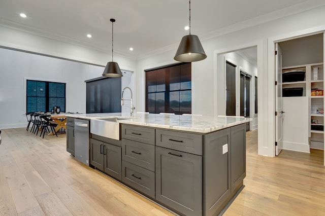 kitchen with a center island with sink, sink, and hanging light fixtures