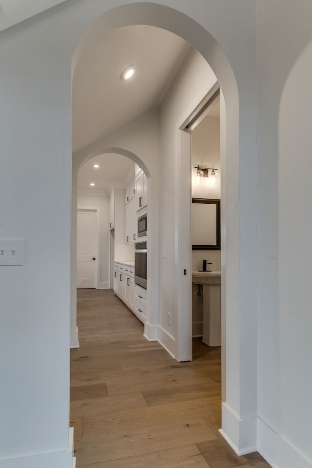 hall featuring light hardwood / wood-style flooring and ornamental molding