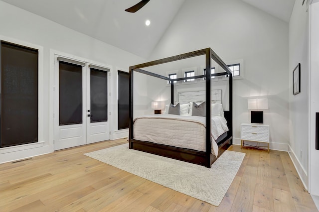 bedroom featuring light wood-type flooring, high vaulted ceiling, and ceiling fan