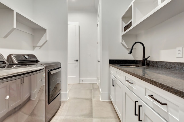 laundry room featuring cabinets, independent washer and dryer, sink, and light tile patterned floors