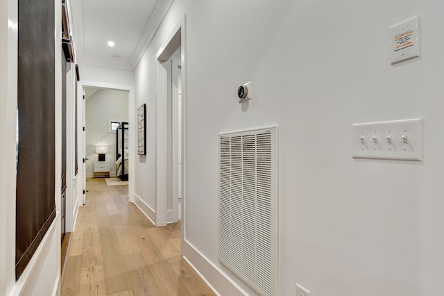 hall featuring light wood-type flooring and crown molding