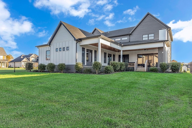 back of property with a lawn and a porch