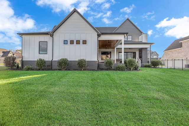 rear view of house featuring a yard and ceiling fan