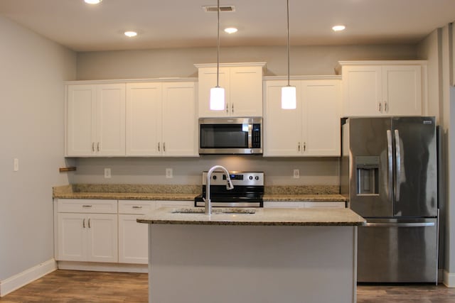 kitchen featuring white cabinets, decorative light fixtures, and stainless steel appliances