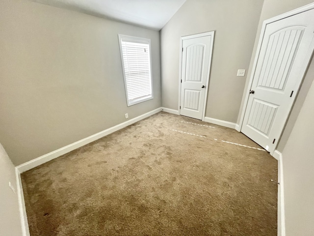 unfurnished bedroom with carpet floors and lofted ceiling