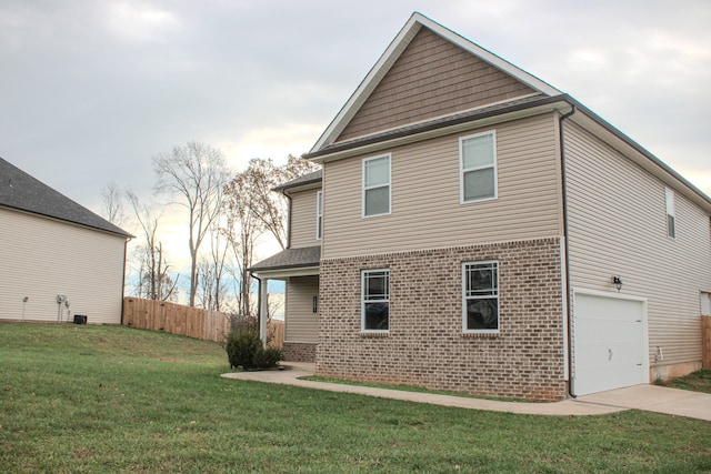 rear view of house with a garage and a yard