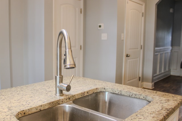 kitchen featuring light stone counters, sink, and dark wood-type flooring