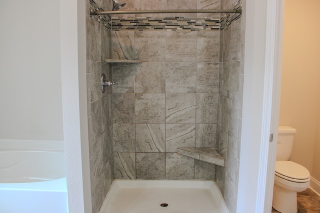 bathroom with toilet and tiled shower