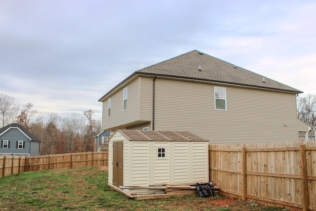 rear view of house with a lawn and a shed