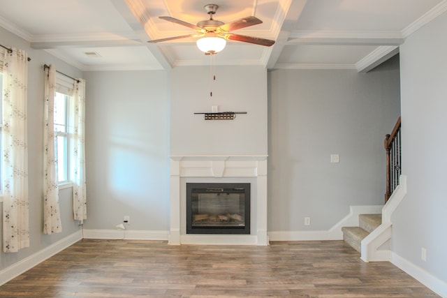 unfurnished living room featuring wood-type flooring, ornamental molding, ceiling fan, and coffered ceiling