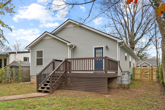 rear view of house with a yard and a deck