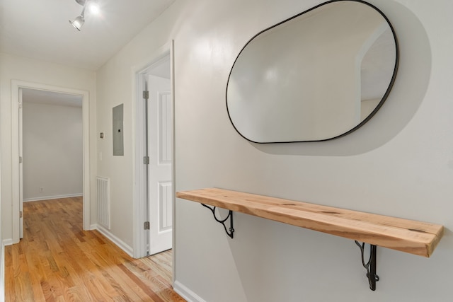 hall with light hardwood / wood-style floors and electric panel