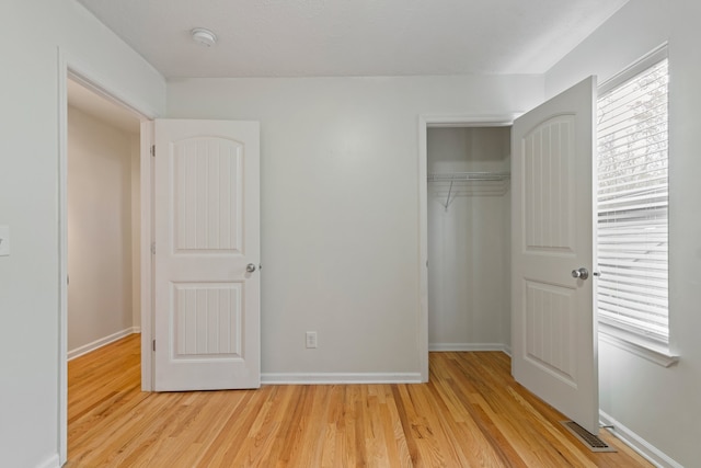 unfurnished bedroom featuring light wood-type flooring and a closet